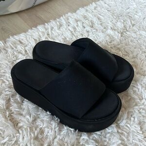 I’m selling black platform slip-on sandals.